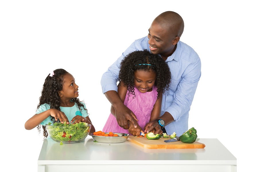 Dad and two daughters making salad together