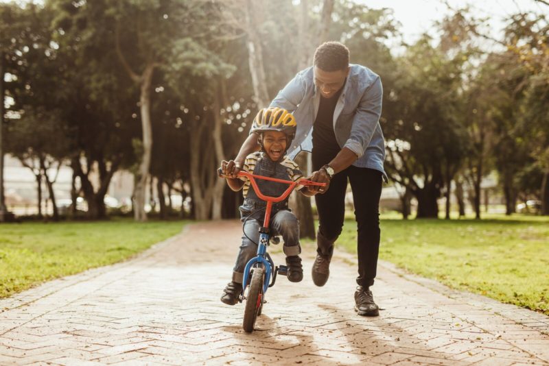 Man teaching his sun how to ride a bicycle