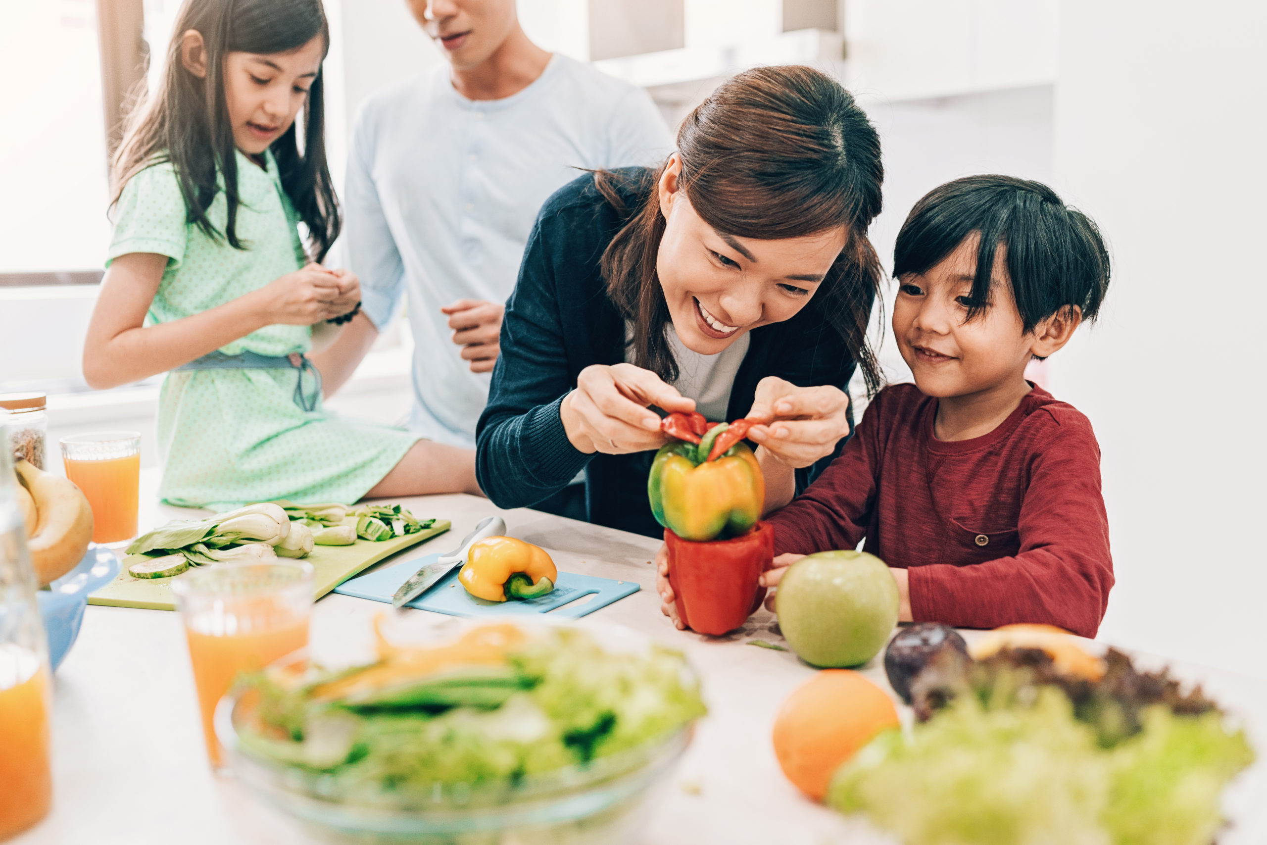 Family preparing salad with peppers in the kitchen