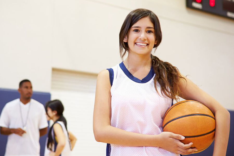 Girl in basketball uniform holding basketball