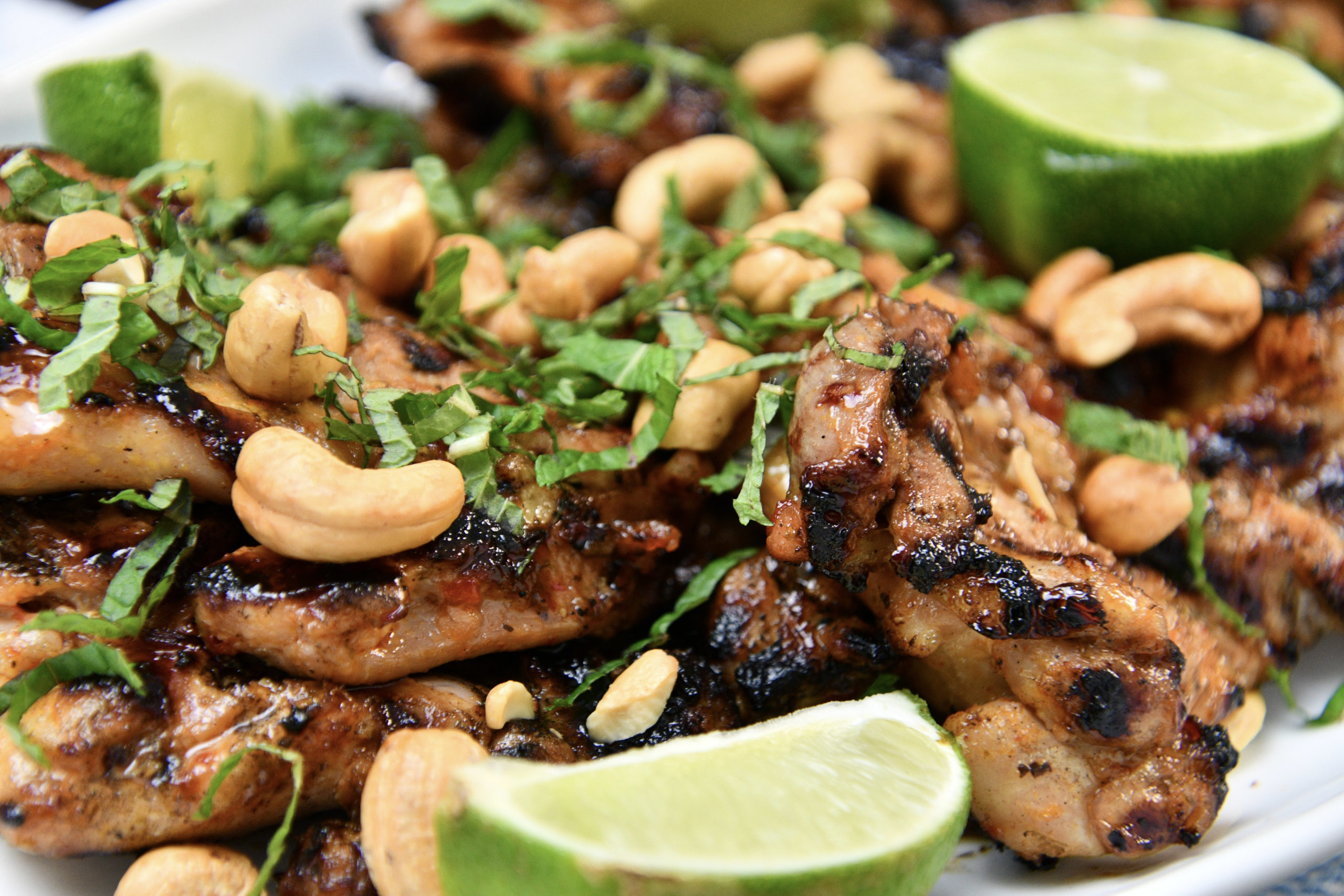 Close up photo of sweet and spicy chicken with limes and cashews