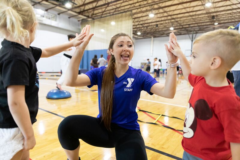 YMCA Staff Member Highfiving Kids