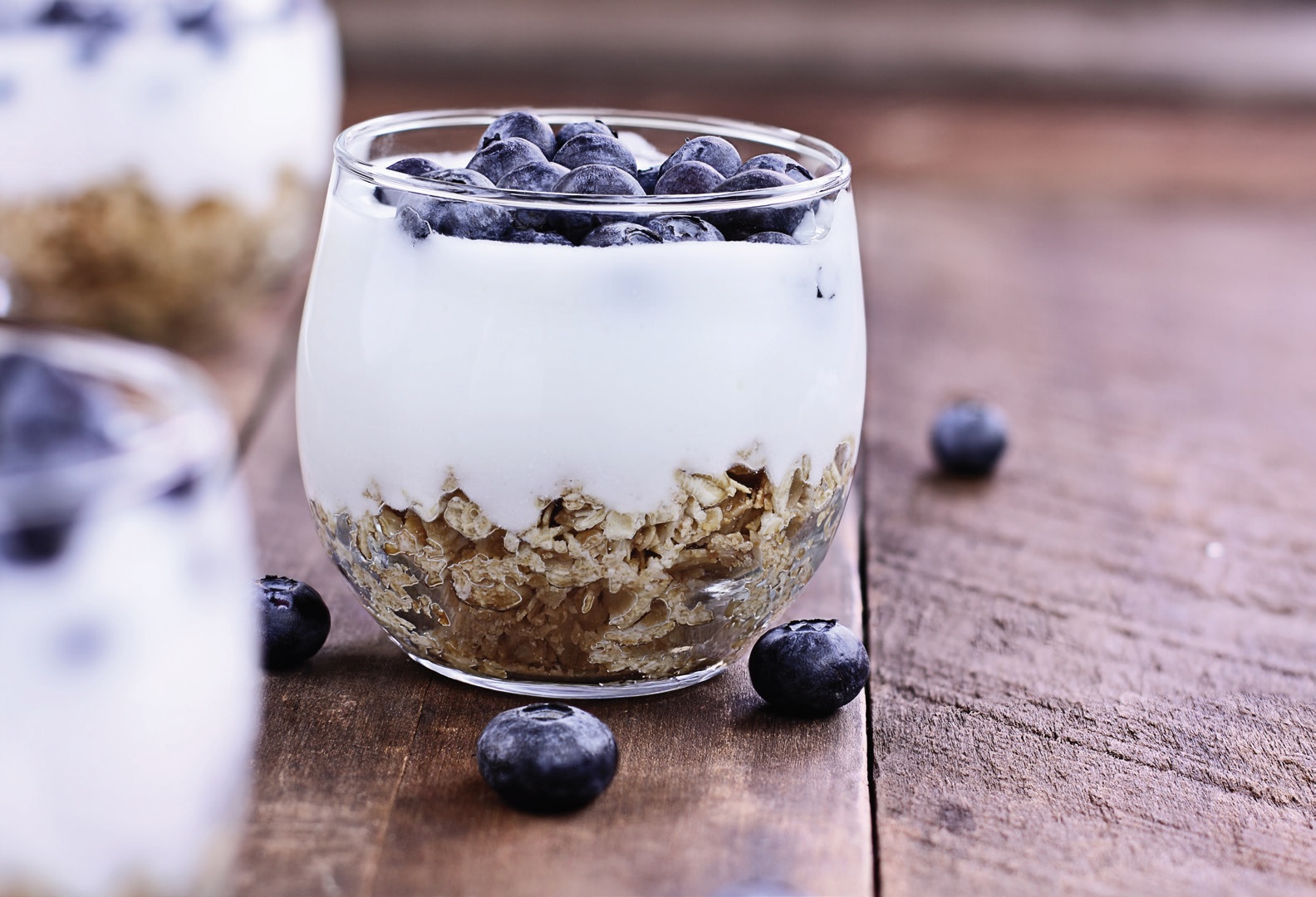 Blueberry yogurt parfait in glass with granola on the bottom