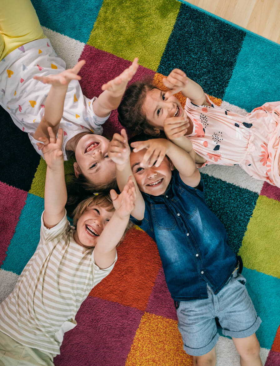 Kids laying on the rug playing in a childcare center