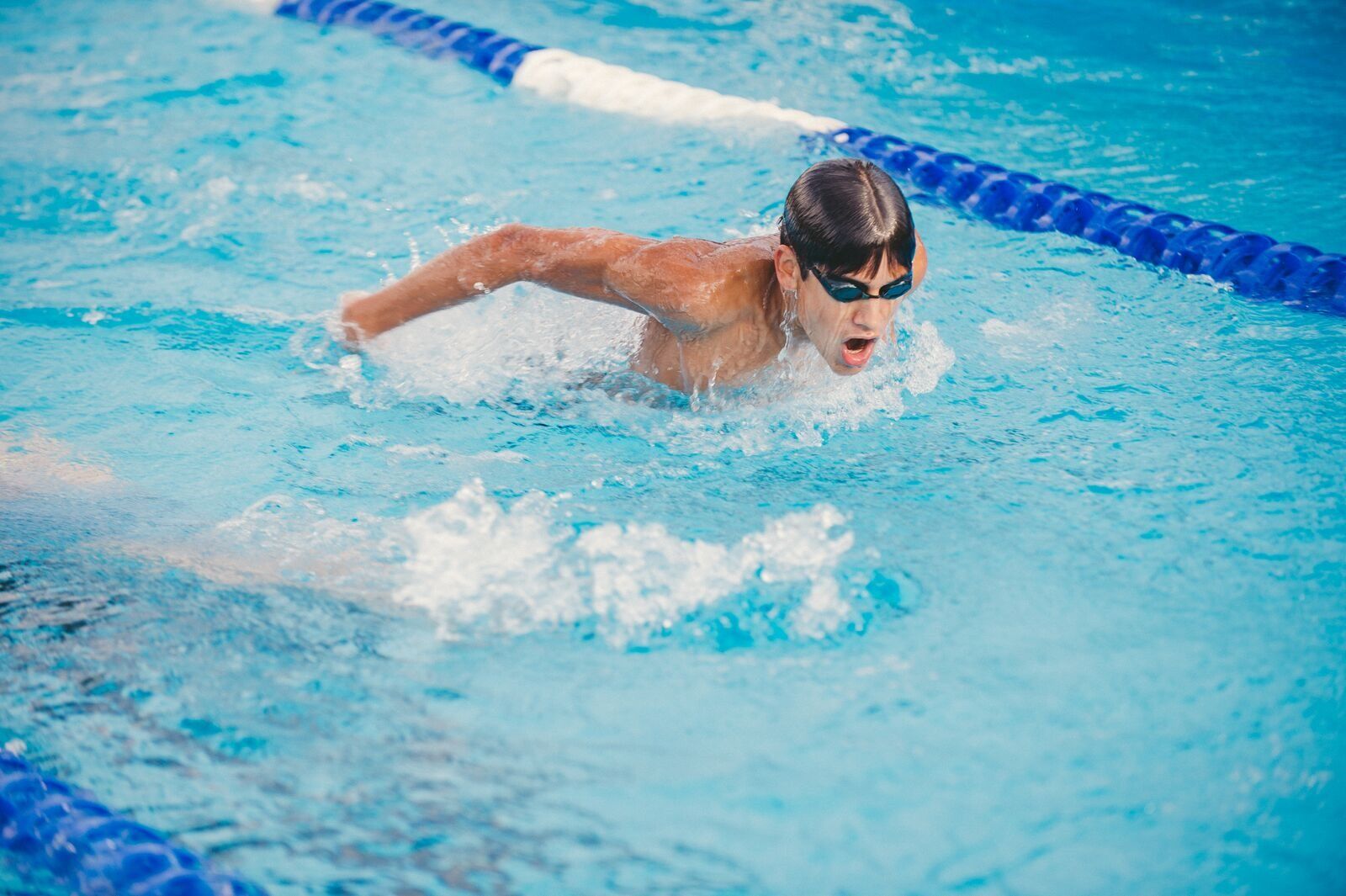 Teen boy doing breast stroke during YMCA swim lesson