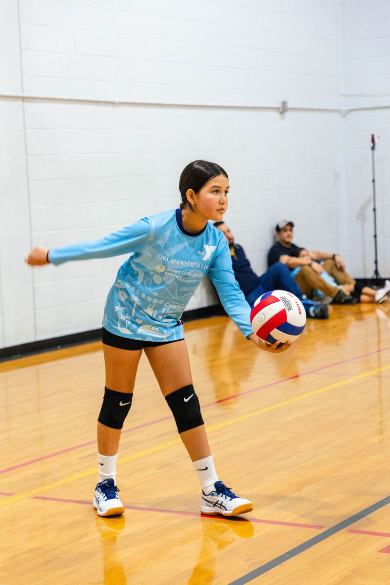 A girl serving during a volleyball game at the YMCA